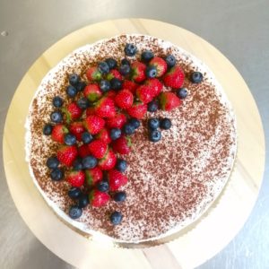 Bezlepkový bezmliečny a vegánsky tekvicový cheesecake potretý vrstvou kokosovej šľahačky a posypaný štipkou škorice.